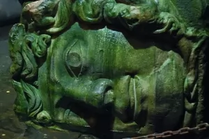 A lying Medusa head carving at the base of a column in the Basilica Cistern.